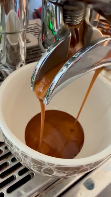 Espresso wird in eine Keramiktasse gegossen